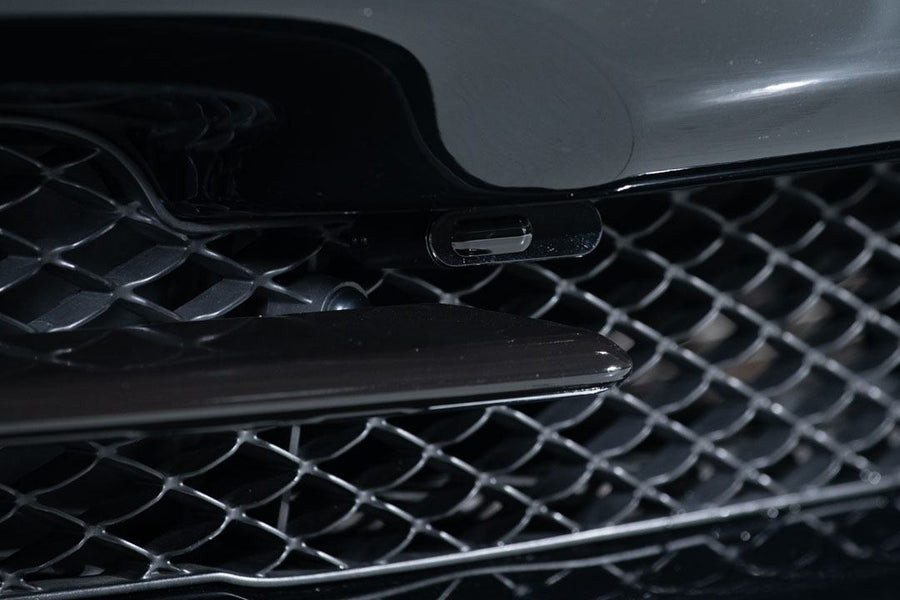 Close-up of a black car grille with mesh detailing and sleek design